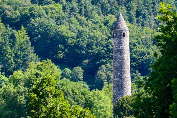 The Round Tower at Glendalough in summer surrounded by trees